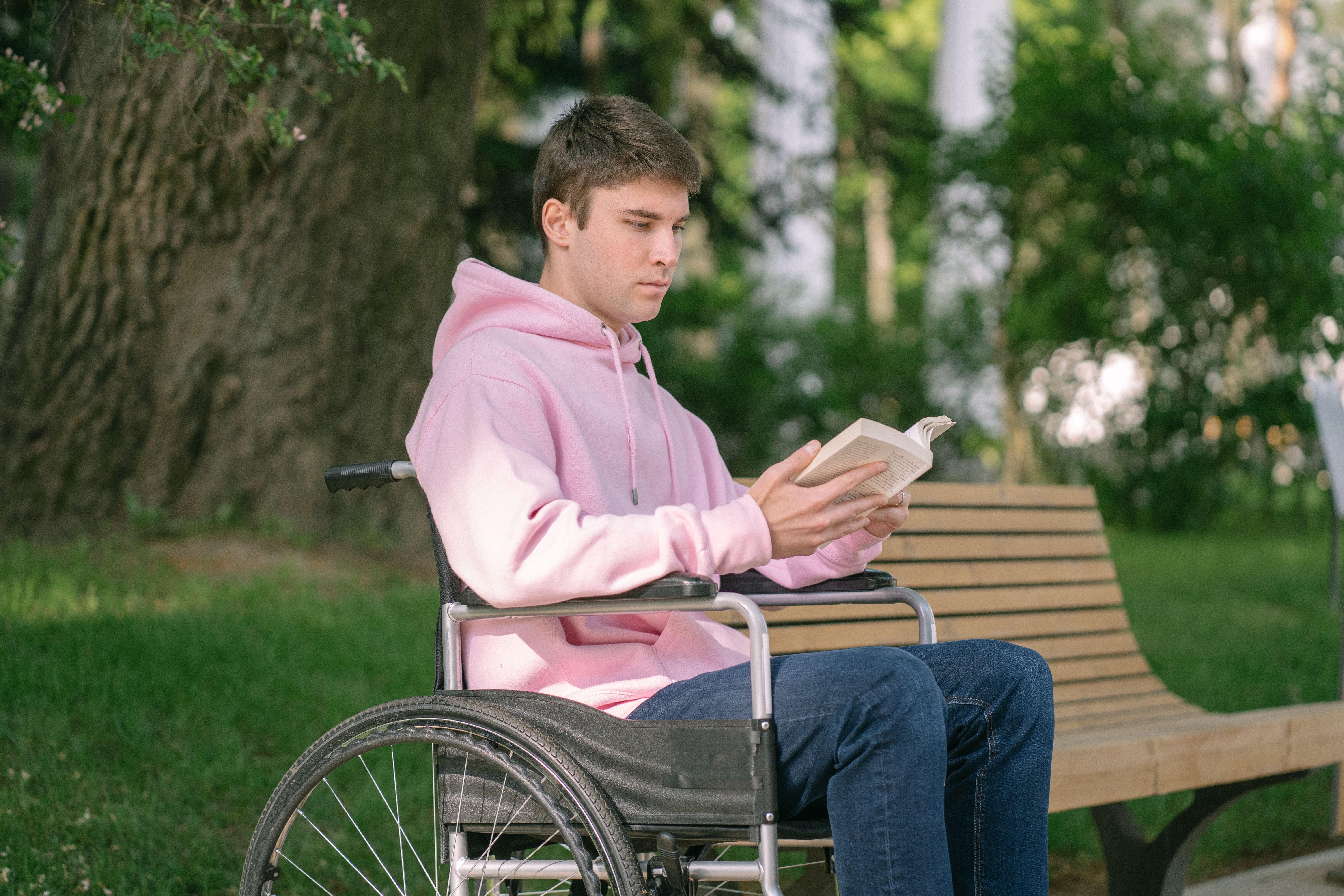 Student cu dizabilități citind în parc